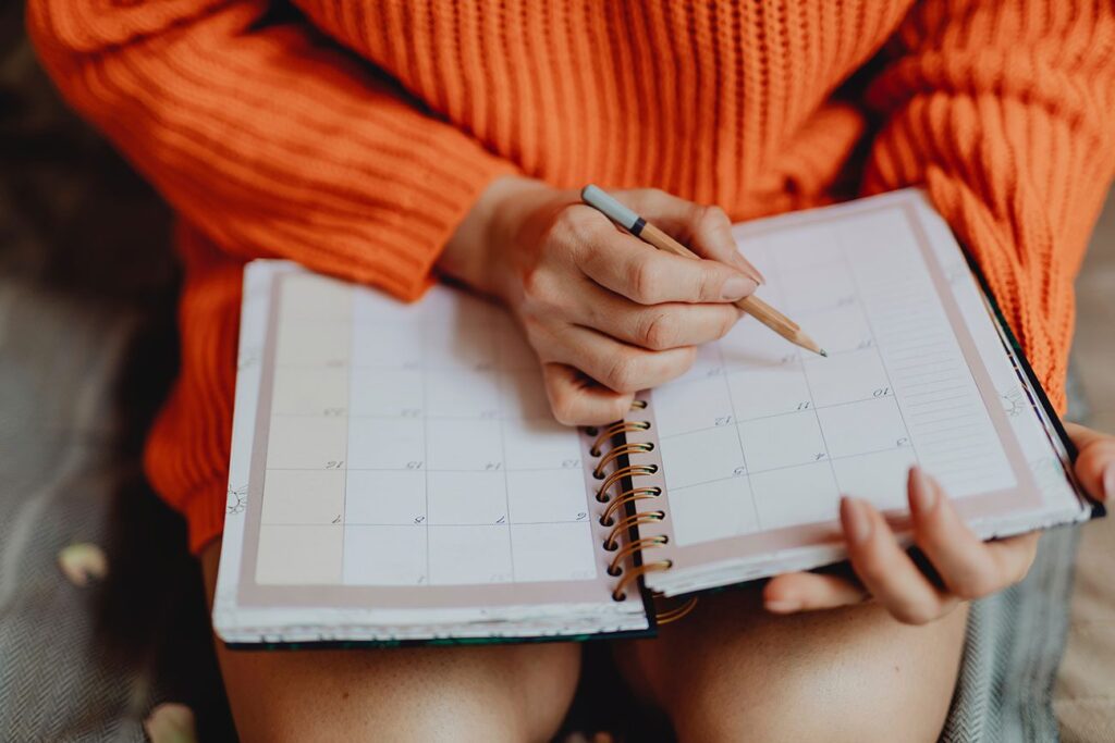 woman making a checklist on a pad of paper about things to do before you move